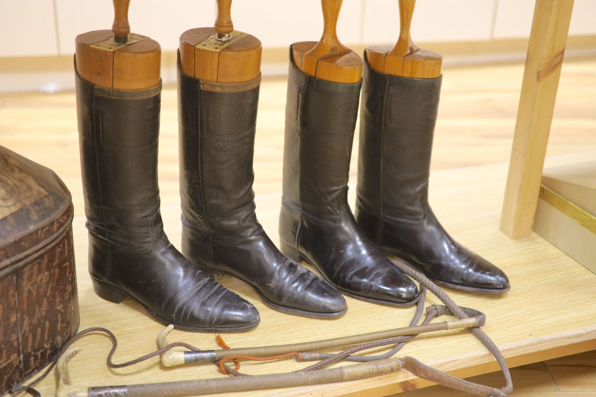 Two pairs of riding boots and trees together with two boot pulls and riding crops and a toleware hat box